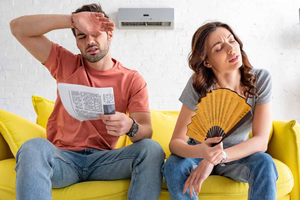 Lakeside ca man and woman using fan to cool down after ac broke down in sumer
