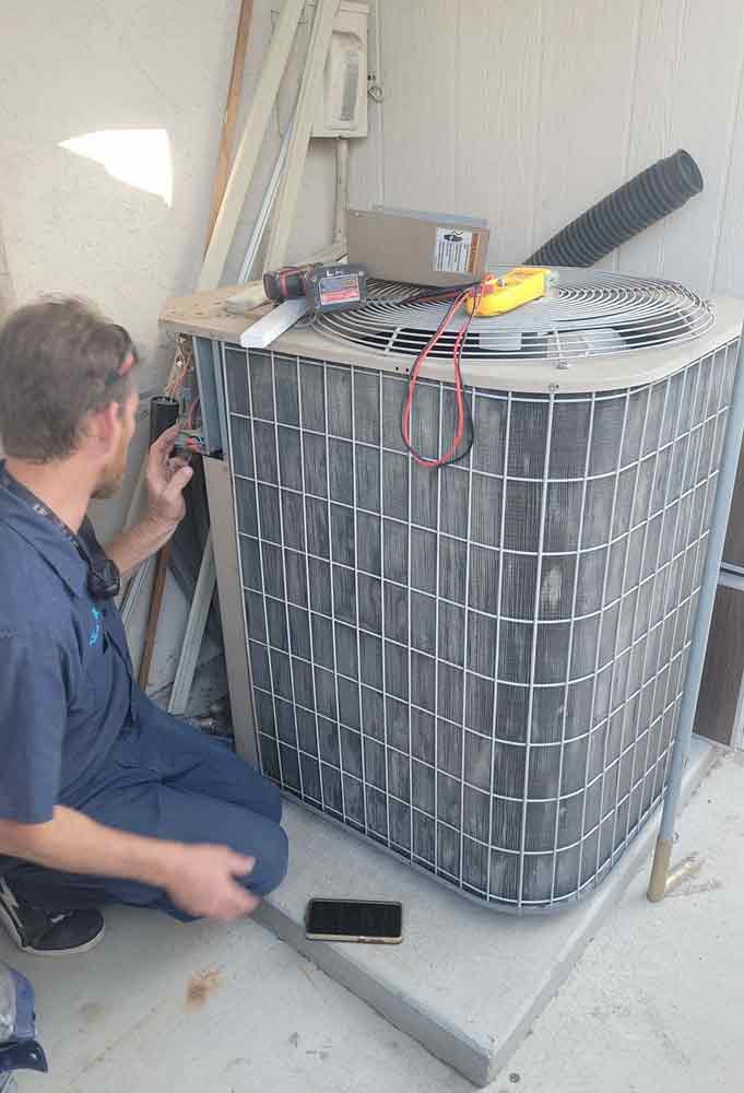 AC repair tech in La Mesa Ca fixing an air conditioner condenser